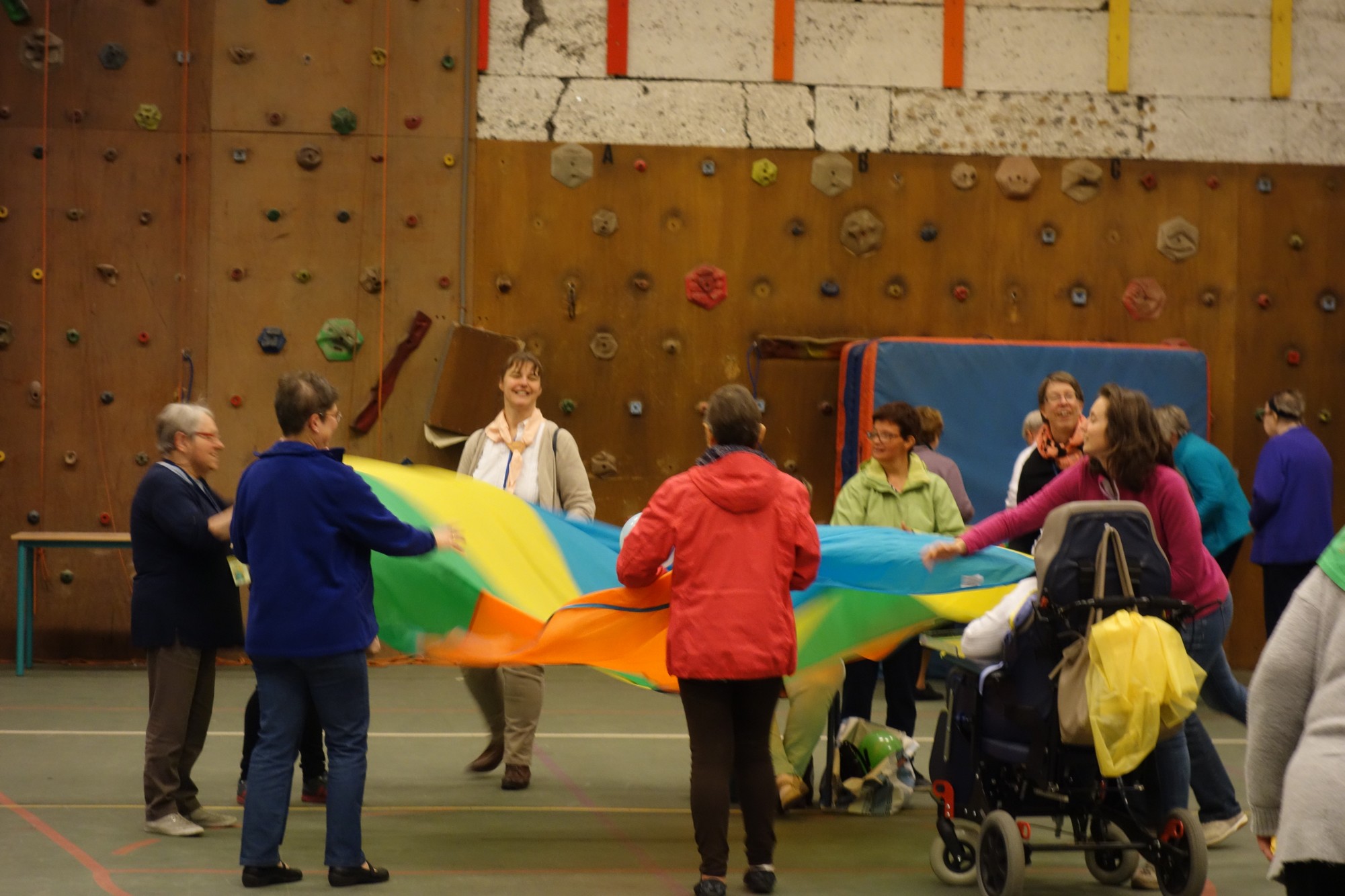 Groupes de personnes en situation de handicap et de volontaires jouant avec un parachute