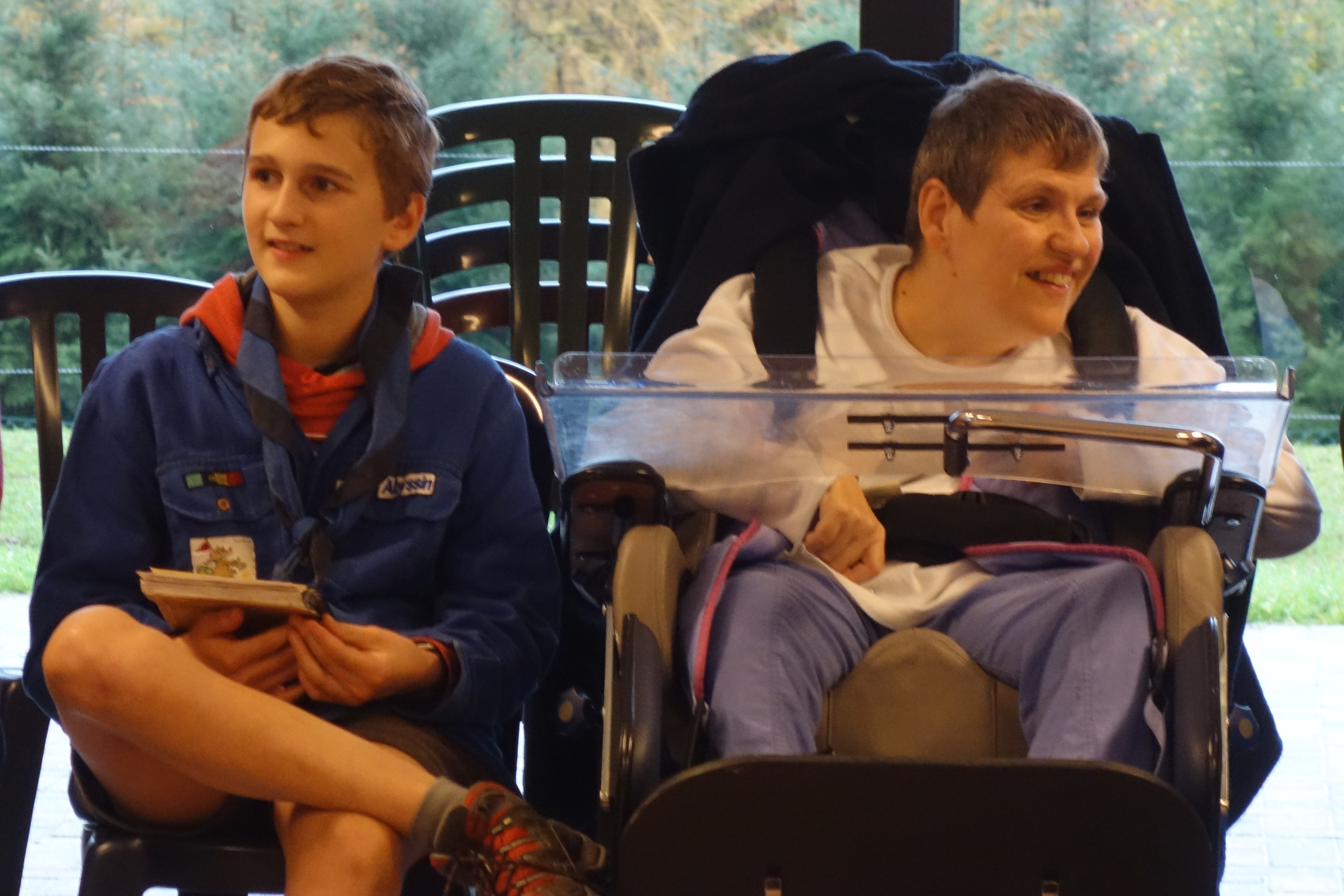 Scout assis à côté d'une personne en situation de handicap