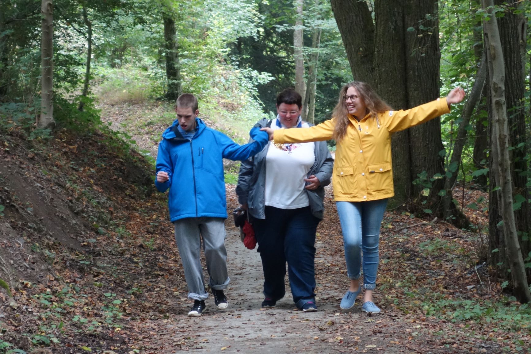 Deux jeunes accompagnent une personne en situation de handicap