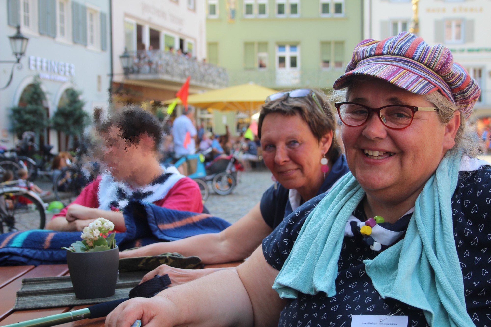 Personne en situation de handicap et ses accompagnateurs assis à une terrasse.